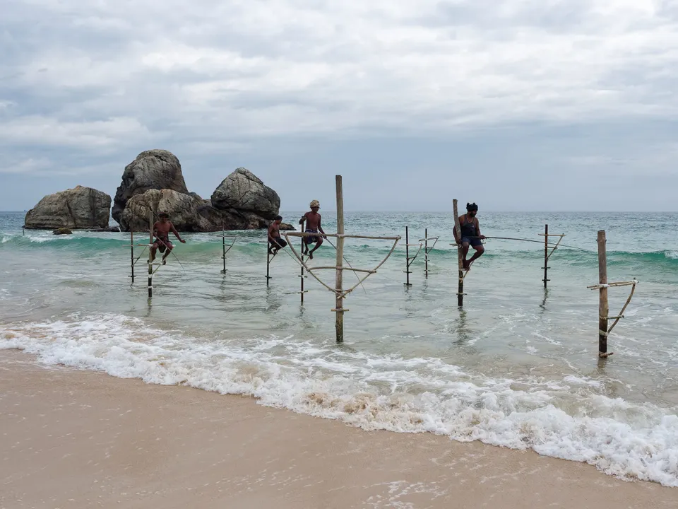 Stilt fishermen balanced over the surf on Sri Lanka's south coast